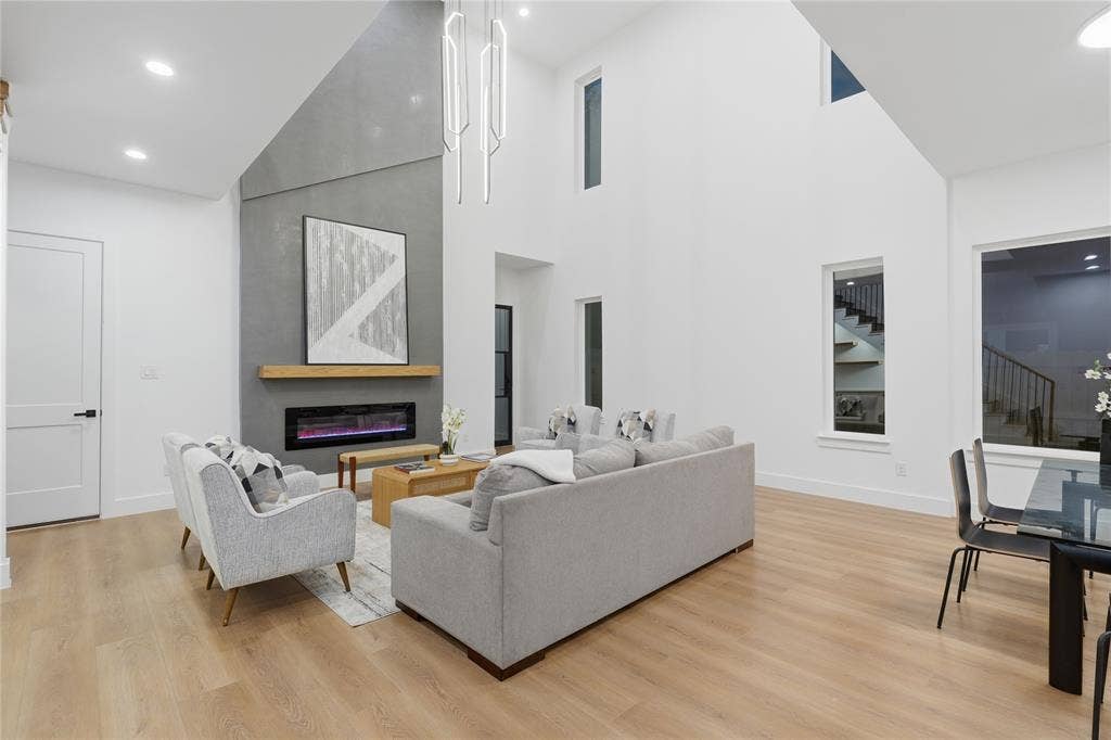 2212 Marburg Street, Dallas, TX 75215 Vaulted ceiling living area featuring a modern fireplace with a concrete-finish surround, light wood mantel, and an inset linear electric fireplace