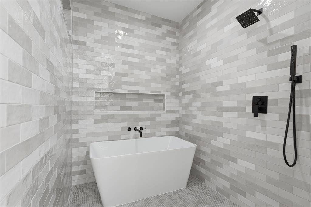 2212 Marburg Street, Dallas, TX 75215 Freestanding soaking tub set against a tiled wall with a recessed niche