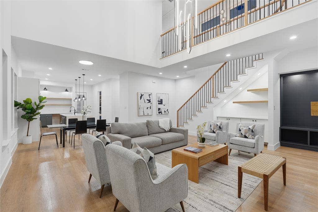 2212 Marburg Street, Dallas, TX 75215 Two-story living area featuring a prominent staircase with wood handrails and black metal balusters