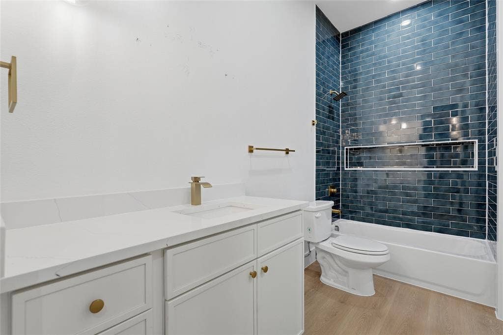 2212 Marburg Street, Dallas, TX 75215 Bathroom featuring a white vanity with gold hardware, a white countertop, and a built-in sink