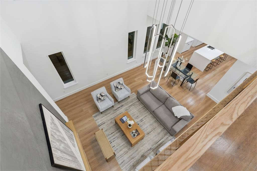 2212 Marburg Street, Dallas, TX 75215 Double-height living space featuring wood-finish flooring, a contemporary linear chandelier, and recessed windows