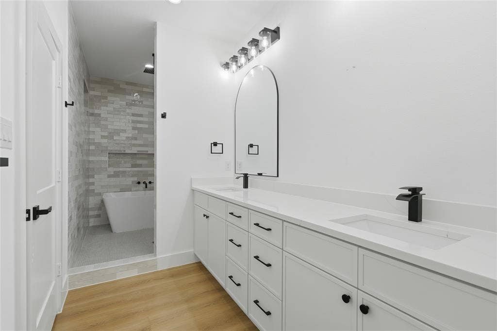 2212 Marburg Street, Dallas, TX 75215 Spacious bathroom with dual vanities featuring white cabinetry, integrated sinks, and matte black fixtures