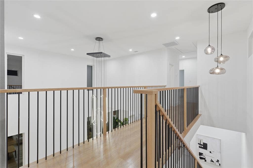 2212 Marburg Street, Dallas, TX 75215 Upper-level hallway featuring wood-finish flooring, light wood handrails with black metal balusters, and recessed lighting