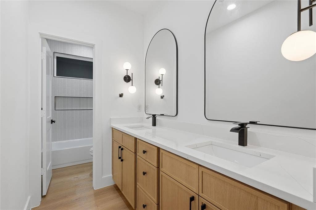 2212 Marburg Street, Dallas, TX 75215 Dual vanity with light wood-finish cabinetry, white countertops, and integrated rectangular sinks