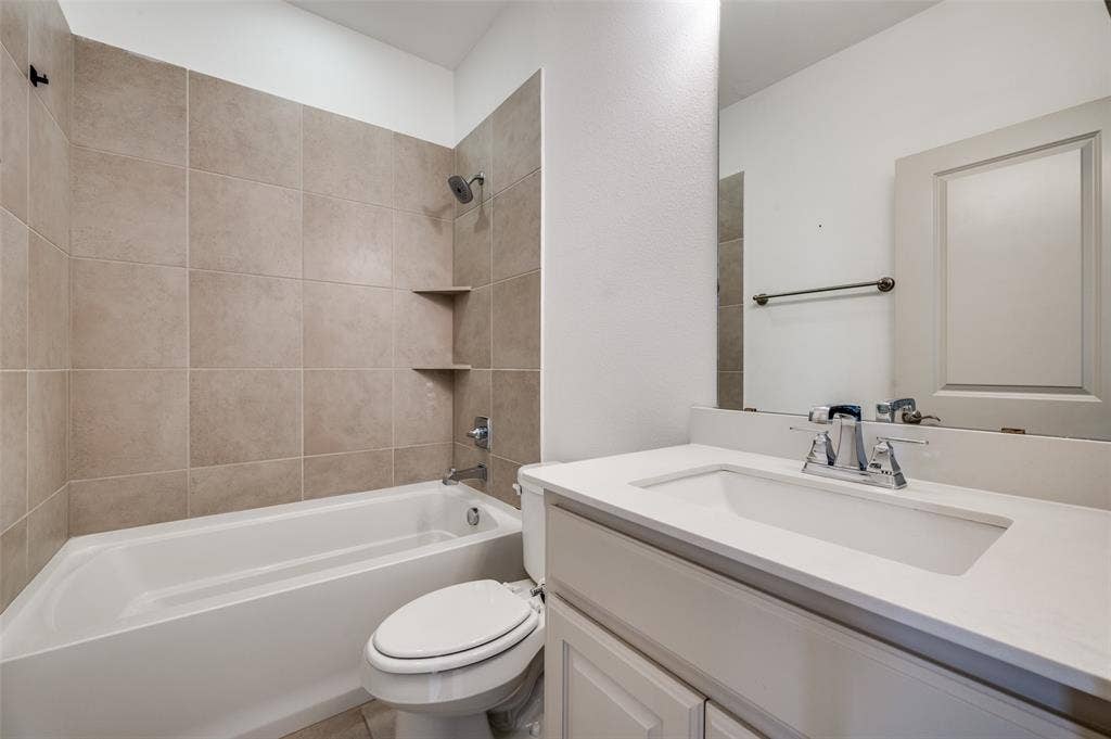 7424 Mitchell Drive, McKinney, TX 75070 Full bathroom with vanity, shower tub combination, neutral tile surround, and simple clean design, serving secondary bedrooms and adding everyday functionality for residents searching for a McKinney TX townhome with multiple full bathrooms in a Collin County suburban neighborhood