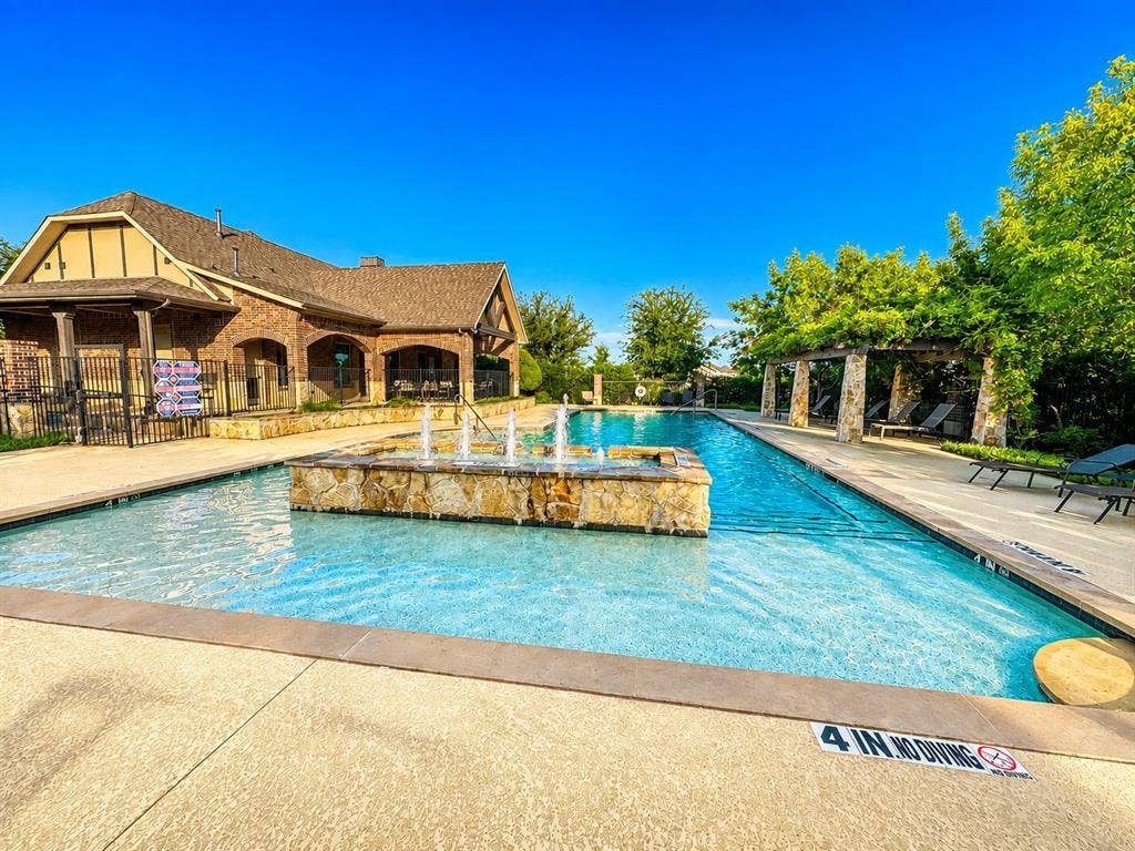 7424 Mitchell Drive, McKinney, TX 75070 Resort-style pool with a stone fountain feature and an expansive deck