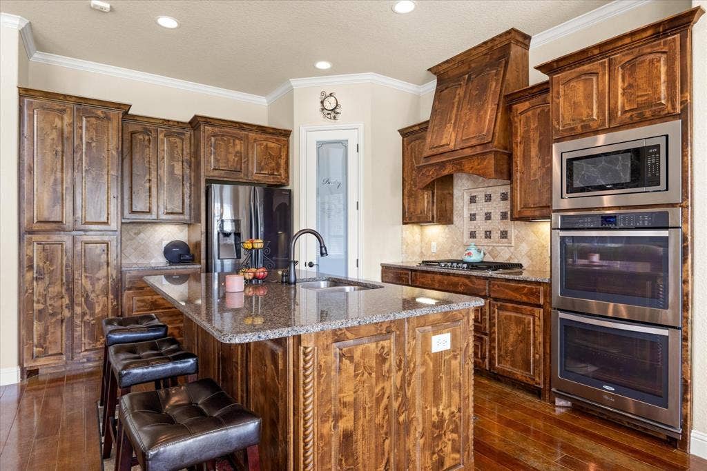 104 Rattling Antler Court, Azle, TX 76020 Custom knotty alder cabinets, plenty of storage, beautiful natural light.