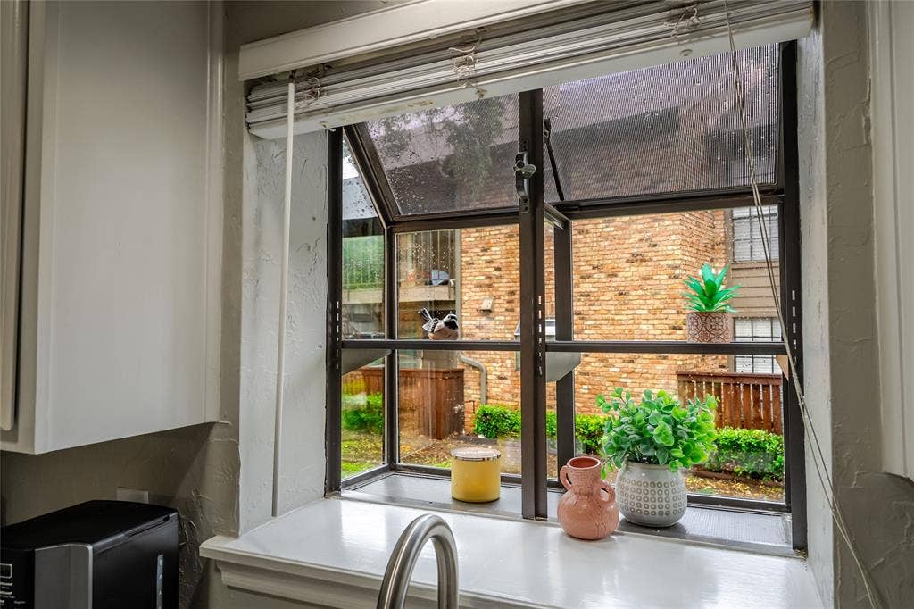 15221 Berry Trail, #1201, Dallas, TX 75248 Kitchen window featuring a stainless steel faucet, a white countertop, and white cabinetry