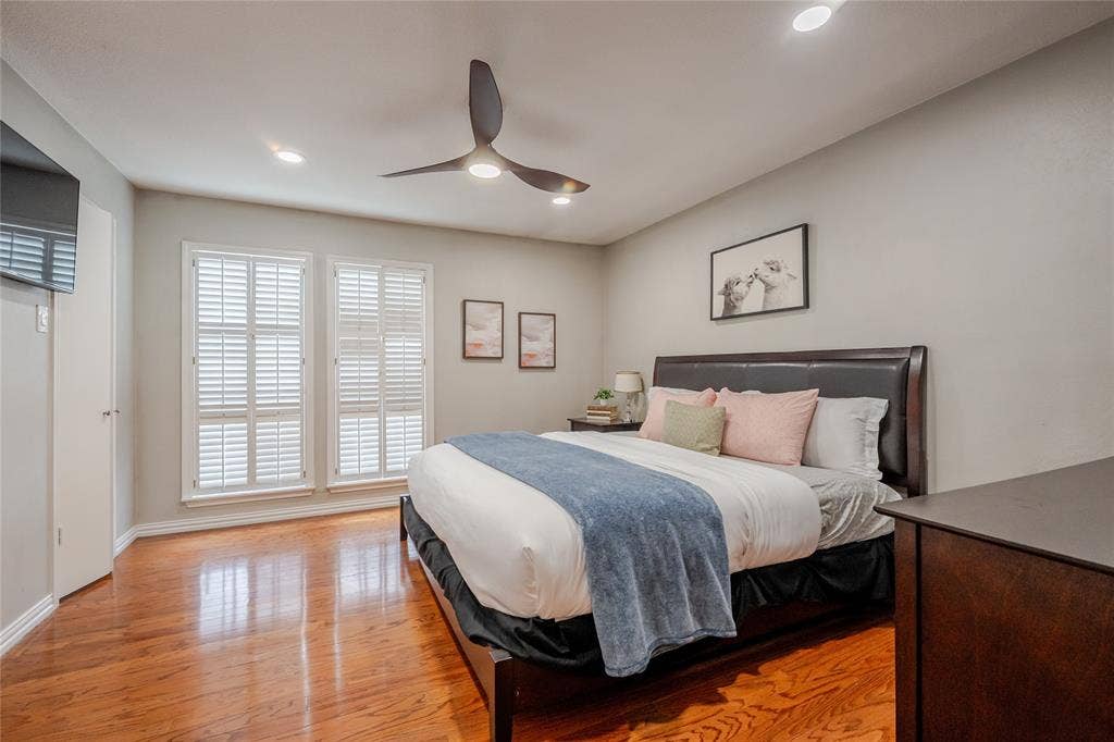 15221 Berry Trail, #1201, Dallas, TX 75248 Spacious room featuring wood-finish flooring, two large windows with plantation shutters, recessed lighting, and a contemporary ceiling fan