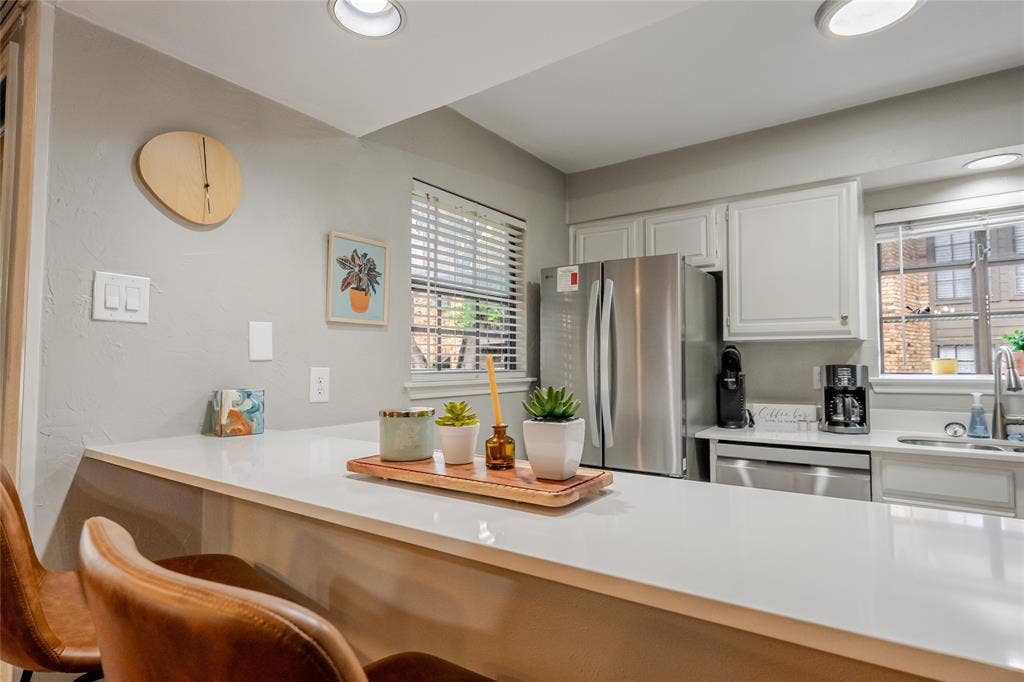 15221 Berry Trail, #1201, Dallas, TX 75248 Kitchen featuring a white countertop island, stainless steel appliances, white cabinetry, recessed lighting, and a window with blinds