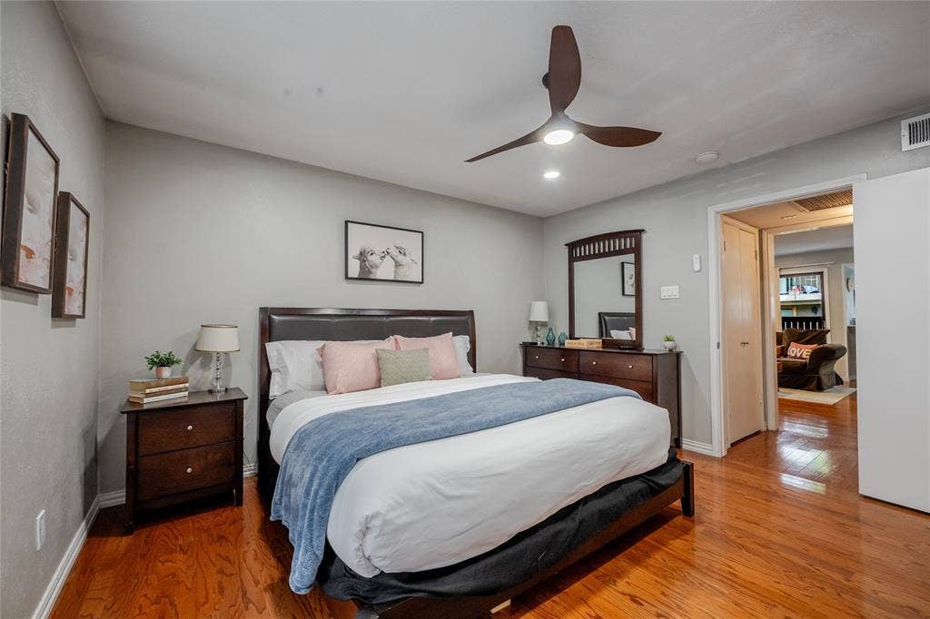 15221 Berry Trail, #1201, Dallas, TX 75248 Spacious sleeping area featuring wood-finish flooring, a contemporary ceiling fan with integrated lighting, recessed overhead lighting, and ample wall space