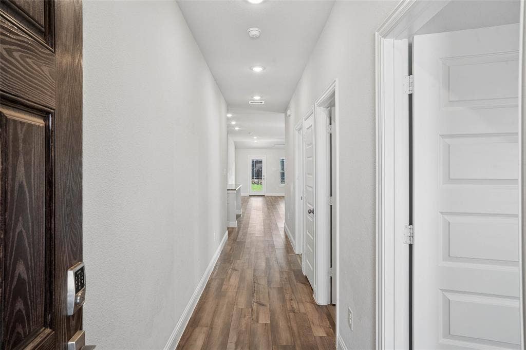 317 Fire Rock Drive, Royse City, TX 75189 Long hallway featuring wood-finish flooring and recessed lighting