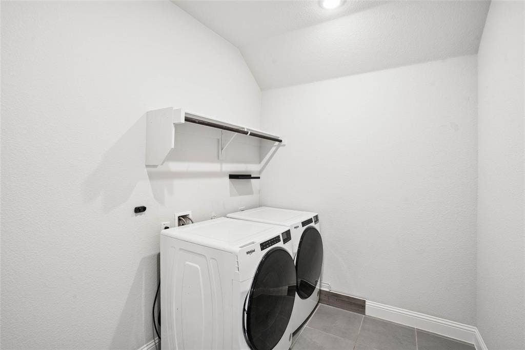 317 Fire Rock Drive, Royse City, TX 75189 Dedicated laundry space featuring white textured walls, recessed ceiling lighting, a built-in shelf with a hanging rod, and grey tile flooring