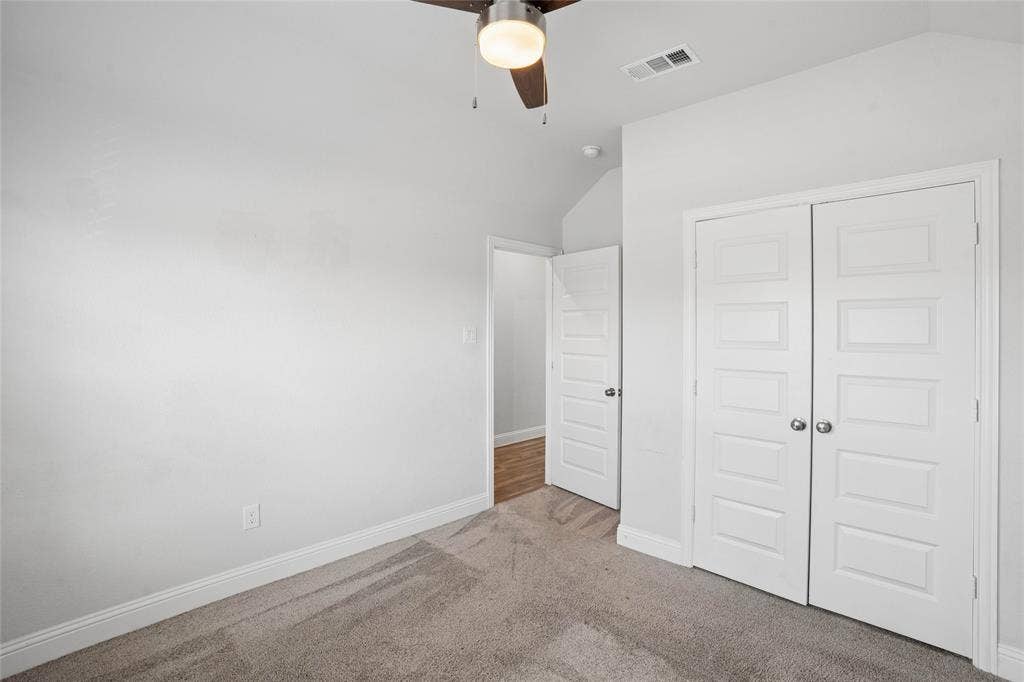 317 Fire Rock Drive, Royse City, TX 75189 Bedroom featuring neutral carpeting, white trim, a ceiling fan with integrated lighting, and a closet with bifold panel doors