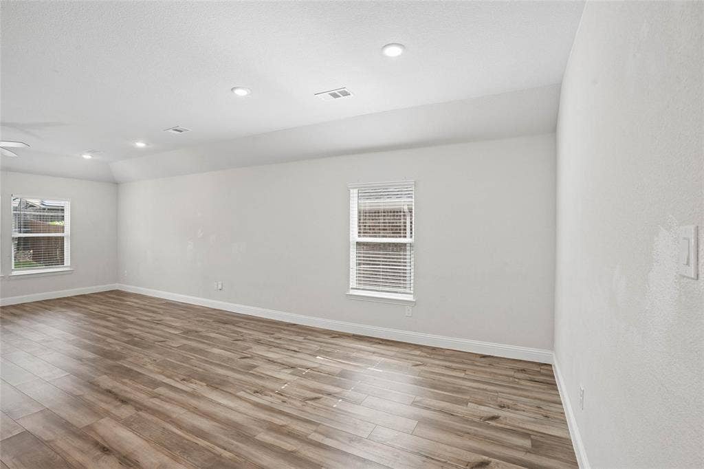 317 Fire Rock Drive, Royse City, TX 75189 Spacious room featuring wood-finish flooring, white baseboards, and neutral wall paint