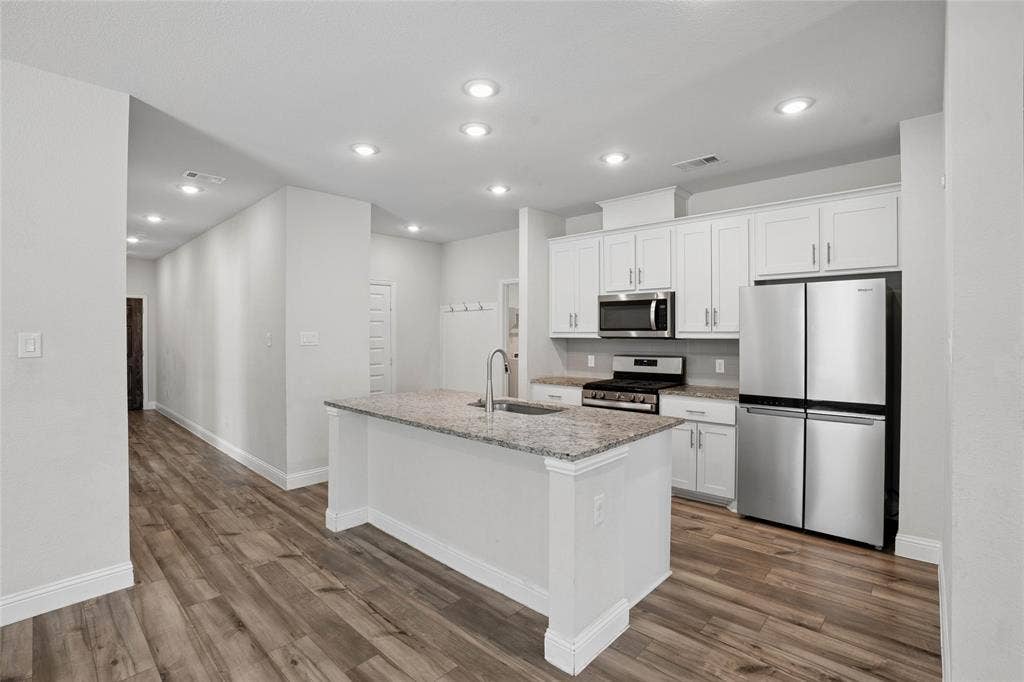 317 Fire Rock Drive, Royse City, TX 75189 Kitchen with white shaker cabinetry, stainless steel appliances, and granite countertops