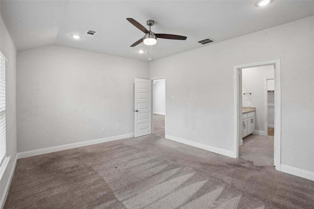 317 Fire Rock Drive, Royse City, TX 75189 Spacious interior room featuring vaulted ceilings, recessed lighting, a ceiling fan, and grey carpet flooring