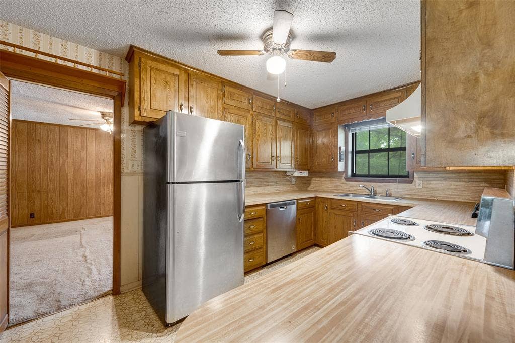 8798 Hill N Dale Road, Tyler, TX 75709 Kitchen featuring wood cabinetry, stainless steel refrigerator and dishwasher, electric range, and wood-finish countertops