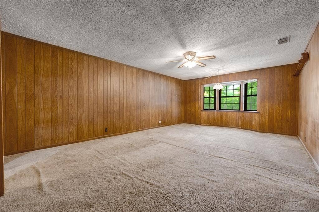 8798 Hill N Dale Road, Tyler, TX 75709 Spacious interior with full wood paneling and a textured ceiling