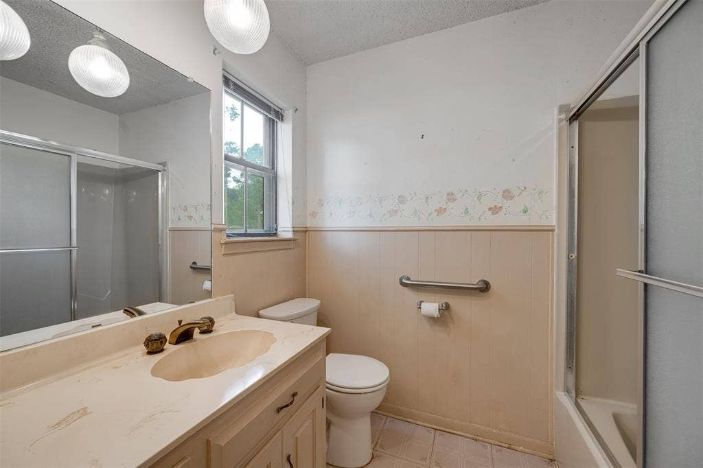8798 Hill N Dale Road, Tyler, TX 75709 Bathroom vanity with an integrated sink, dual light fixtures, a large wall mirror, and a window providing natural light