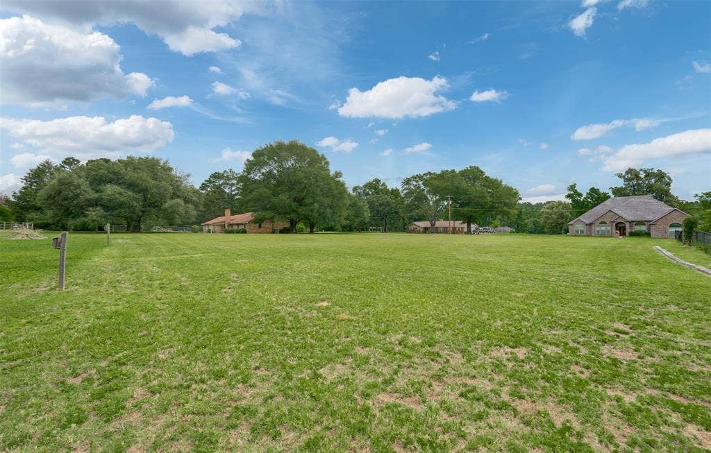 8798 Hill N Dale Road, Tyler, TX 75709 Expansive grassy area with lush trees bordering the property