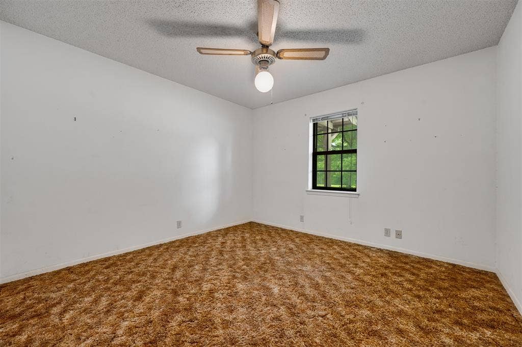 8798 Hill N Dale Road, Tyler, TX 75709 Neutral white walls with textured ceiling and brown shag carpet