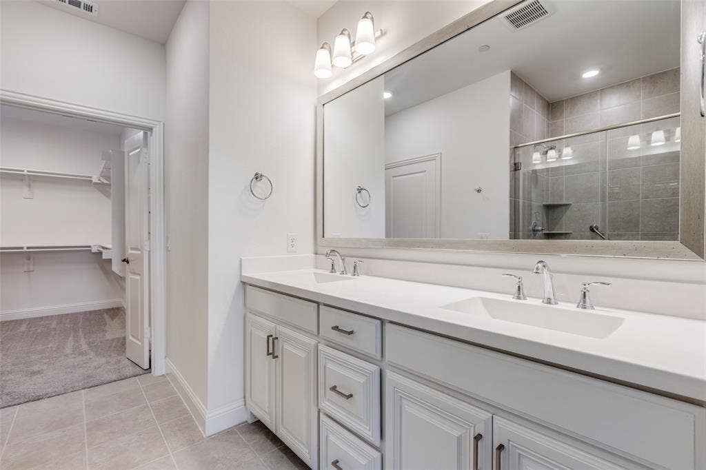 3930 Dalea Drive, Prosper, TX 75078 Bathroom featuring a double vanity with white cabinetry, integrated sinks, and chrome fixtures