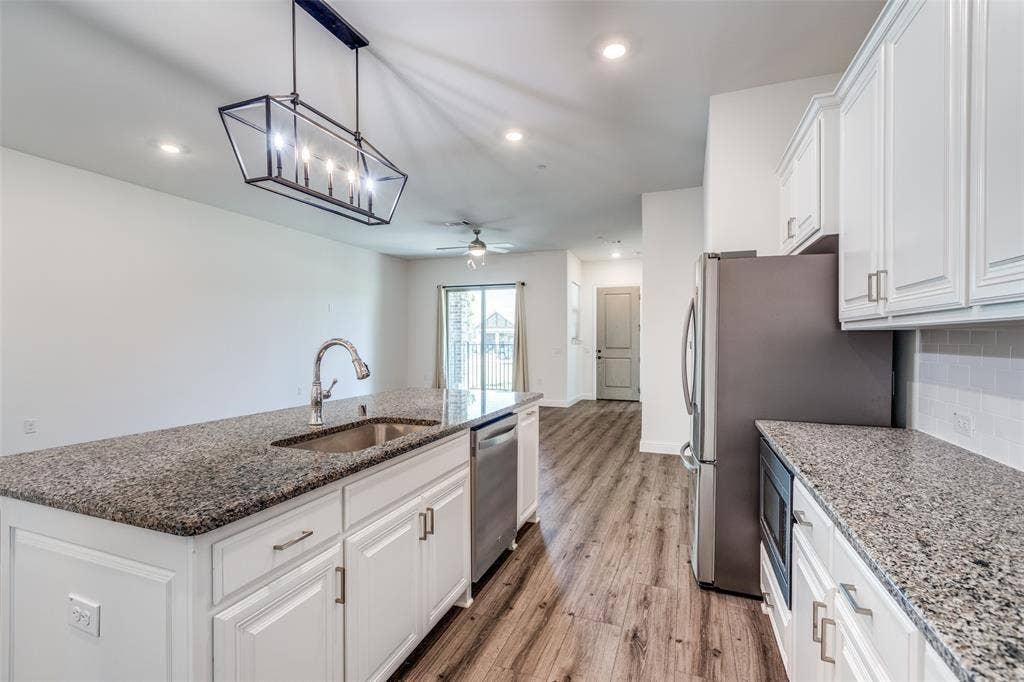 3930 Dalea Drive, Prosper, TX 75078 Kitchen featuring granite countertops, white cabinetry, stainless steel appliances, and wood-finish flooring