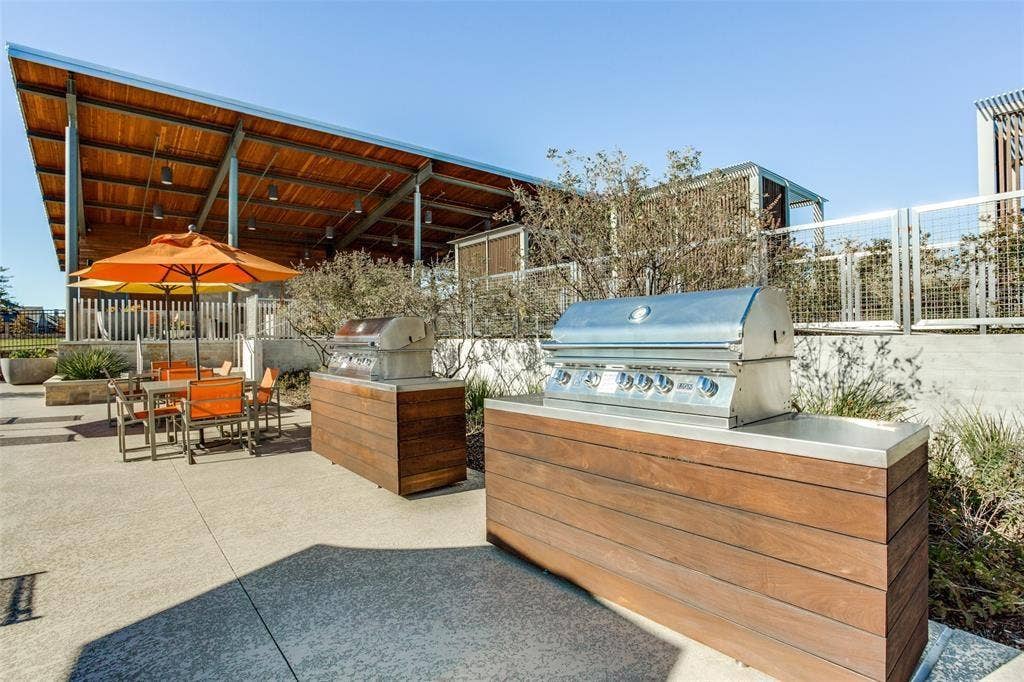 3930 Dalea Drive, Prosper, TX 75078 Expansive outdoor patio featuring built-in stainless steel grills with wood-finish bases and integrated countertops