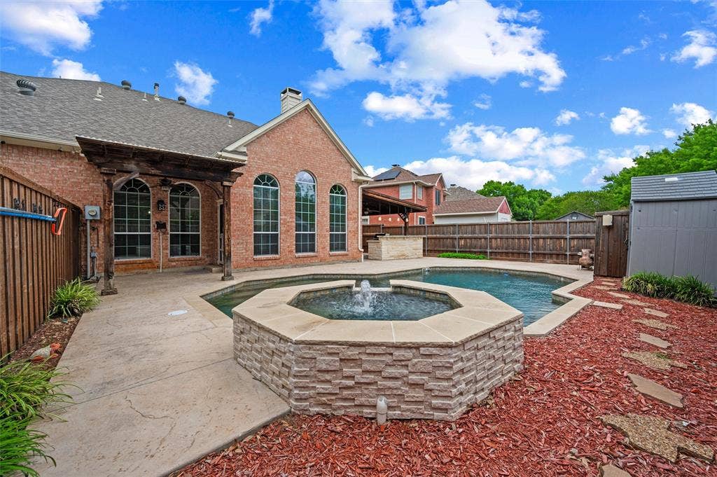 2228 Amy Lane, Plano, TX 75074 Pebble Tech Pool and attached SPA with waterfall; Stamped Concrete on decking for easy walking; storage shed for pool equipment