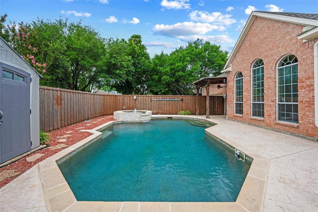 2228 Amy Lane, Plano, TX 75074 Large area for sun bathing - pebble tech pool - auto refil - fountain and waterfall on the spa - storage bldg to hte left for pool supplies - board on board privacy fence