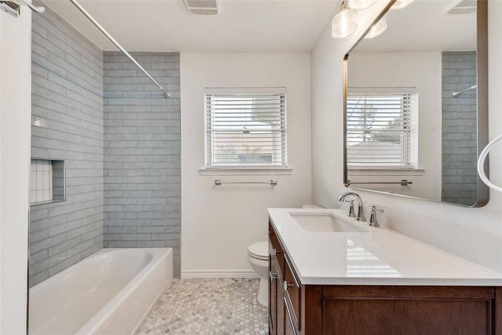 2523 San Medina Avenue, Dallas, TX 75228 Bathroom featuring a white bathtub with light gray subway tile surround and integrated niche