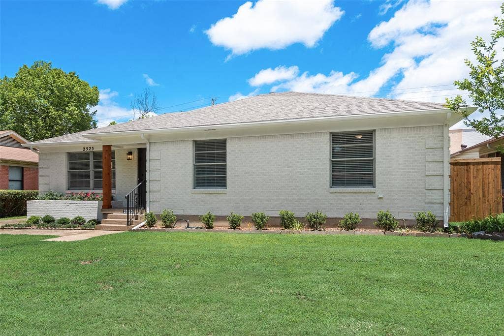 2523 San Medina Avenue, Dallas, TX 75228 Single-story residence featuring a painted brick exterior, a covered entryway with a substantial wood support column, a dark metal handrail, and a raised planter box at the front