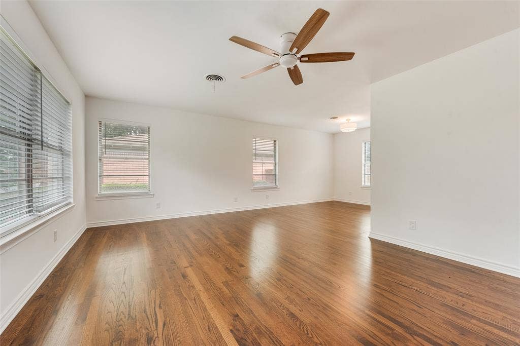 2523 San Medina Avenue, Dallas, TX 75228 Spacious interior featuring wood-finish flooring, white walls, and multiple windows with blinds