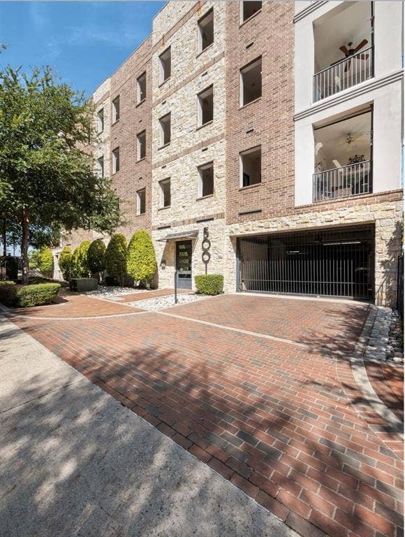 5001 Meridian Lane, #2103, Addison, TX 75001 Brick paver driveway leading to a multi-story building featuring stone and brick facade