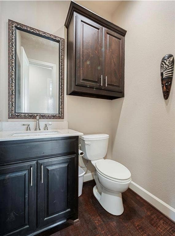 5001 Meridian Lane, #2103, Addison, TX 75001 Bathroom featuring dark wood-finish flooring, a white toilet, and a vanity with a white countertop and dark cabinetry