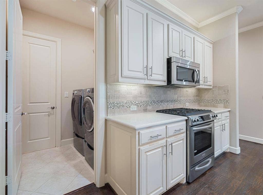 5001 Meridian Lane, #2103, Addison, TX 75001 Kitchen area featuring white cabinetry, stainless steel microwave, gas range, and stone countertops
