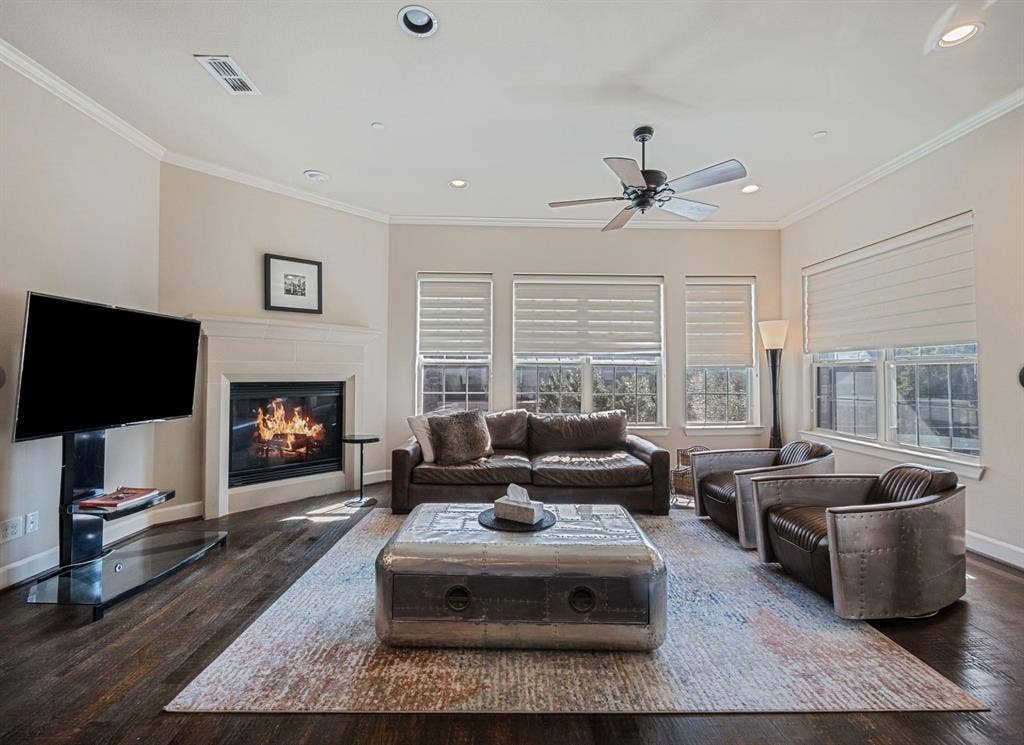 5001 Meridian Lane, #2103, Addison, TX 75001 Living area featuring wood-finish flooring, a white mantel fireplace, and multiple windows with blinds