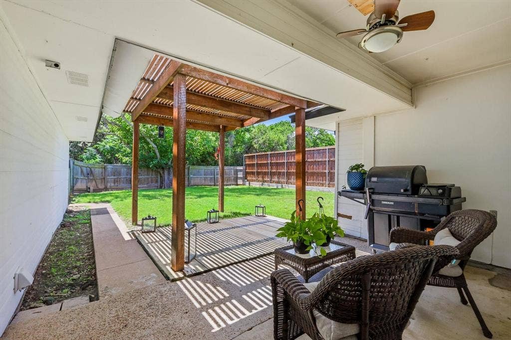 437 Bradshaw Street, Cedar Hill, TX 75104 Covered concrete patio featuring a wood pergola with slatted roof, a ceiling fan with integrated lighting, and a fenced backyard with mature trees