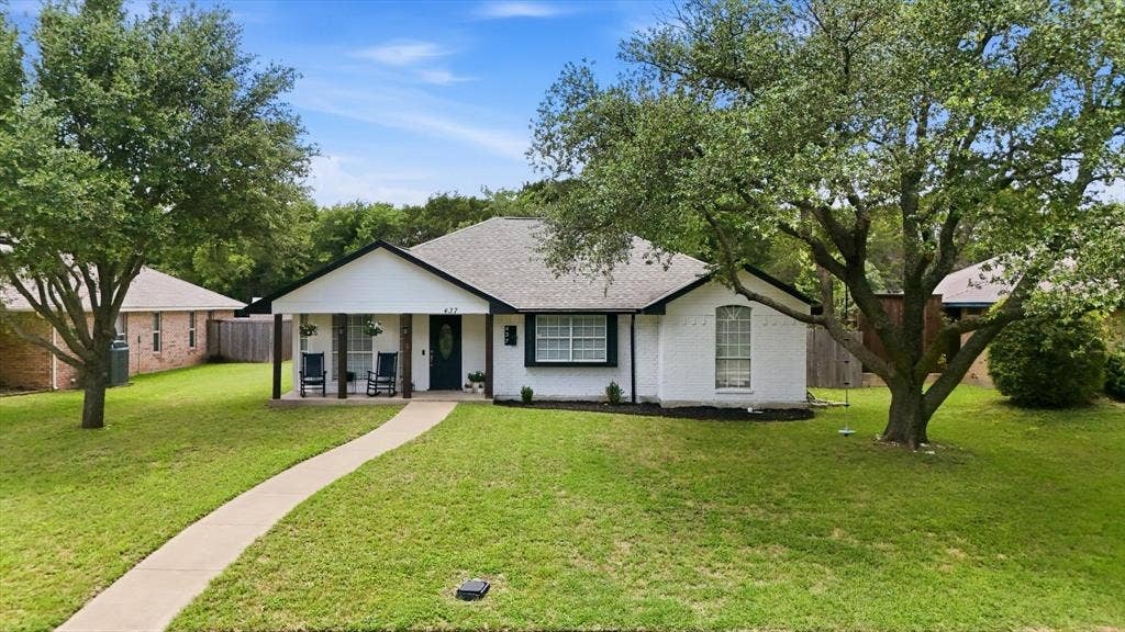 437 Bradshaw Street, Cedar Hill, TX 75104 White brick exterior with black trim accents and a covered front porch featuring wood columns