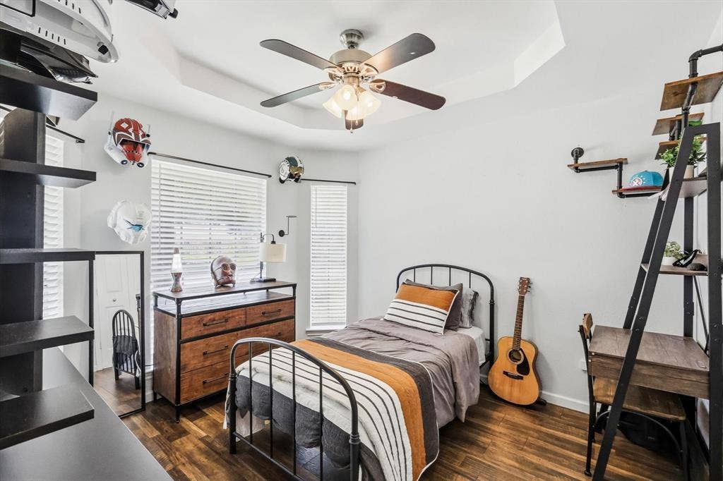 437 Bradshaw Street, Cedar Hill, TX 75104 Spacious room featuring wood-finish flooring, a tray ceiling with a ceiling fan, and multiple windows with horizontal blinds