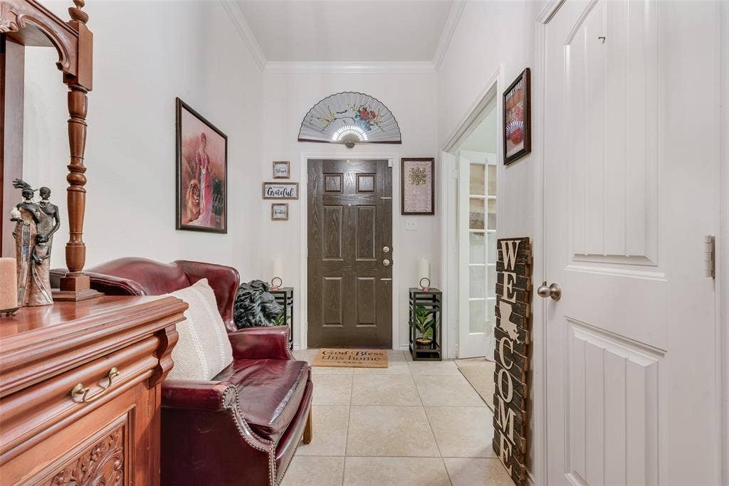 301 Billy Wickliffe Drive, Wilmer, TX 75172 Entryway featuring light-toned tile flooring, a dark wood-finish front door with an arched transom, and crown molding