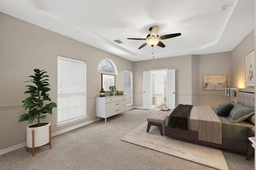 217 Gatehouse Drive, Red Oak, TX 75154 Spacious primary bedroom featuring tray ceiling, ceiling fan, and carpeted flooring