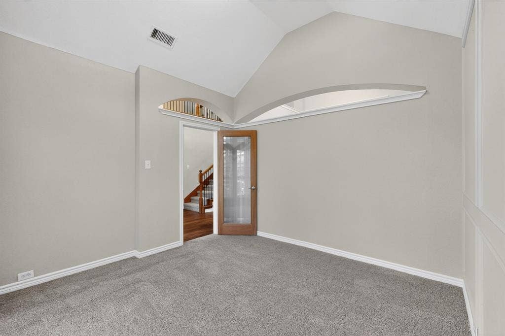 217 Gatehouse Drive, Red Oak, TX 75154 Spacious office featuring vaulted ceilings, neutral-toned walls, and grey textured carpeting