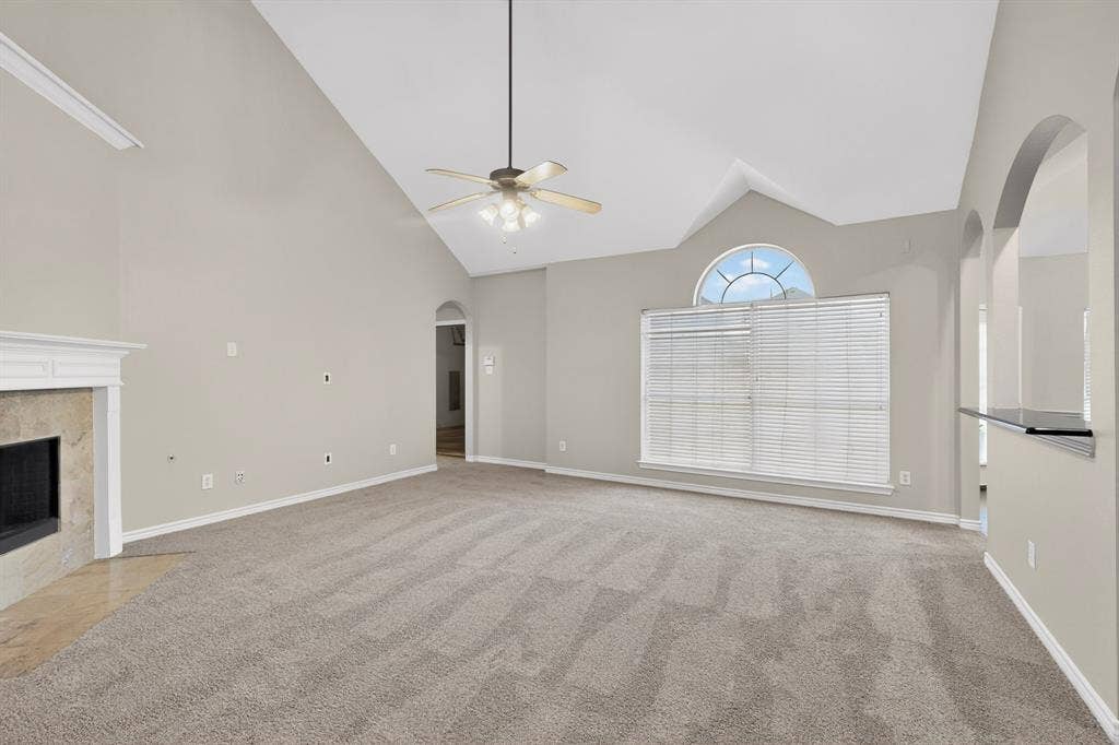 217 Gatehouse Drive, Red Oak, TX 75154 Spacious living area featuring vaulted ceilings, a ceiling fan, and light-toned carpeting