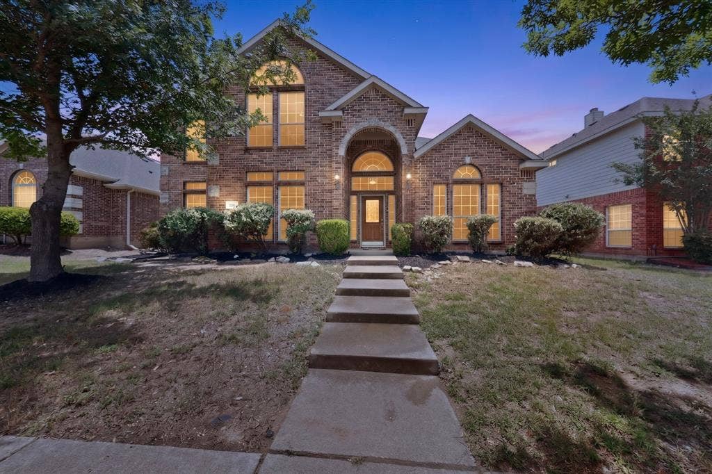 217 Gatehouse Drive, Red Oak, TX 75154 Brick exterior with arched windows, a covered entry, and a concrete pathway