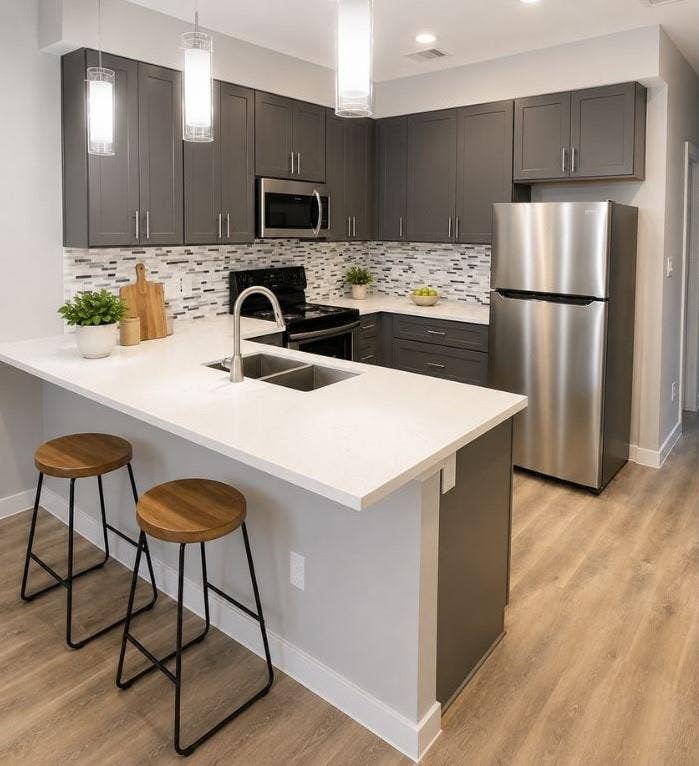 9114 Caddo Road, #A & B, Houston, TX 77078 Virtually Staged - Modern kitchen featuring dark gray cabinetry, stainless steel appliances, white countertops, and a mosaic tile backsplash