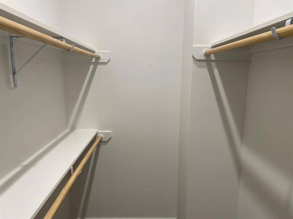 9114 Caddo Road, #A & B, Houston, TX 77078 Walk-in closet featuring white painted walls, white shelving, and natural wood clothing rods