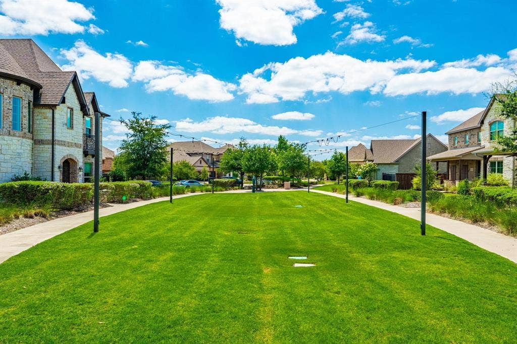 1205 Shady Fox Way, Arlington, TX 76005 Expansive green space featuring a manicured lawn, paved pathways, and decorative string lighting