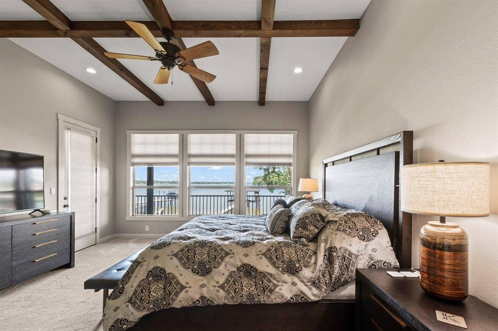 229 N Beverly Drive, Malakoff, TX 75148 Waterside primary suite complemented by wood accents and open-water views plus private patio access.